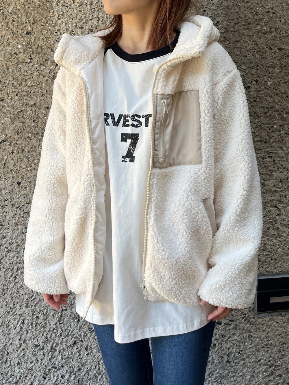 ベージュ系のブルゾン、ブルー系のデニムパンツ、ブラック系のスニーカーを着用したレディースの冬コーディネートの2枚目の写真