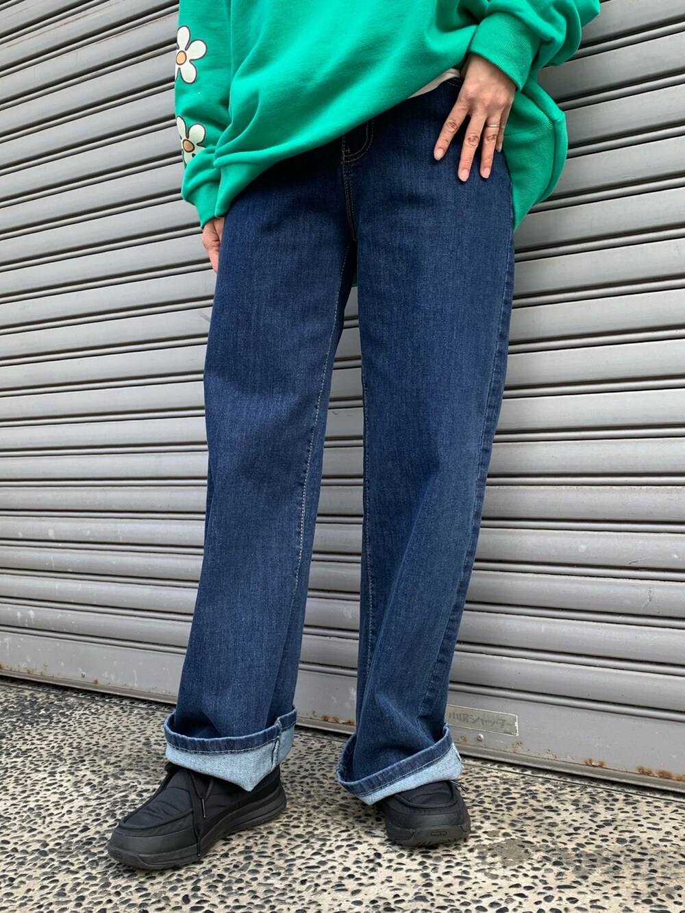 グリーン系のスウェット、ブルー系のデニムパンツ、ブラック系のシューズを着用したレディースの冬コーディネートの7枚目の写真