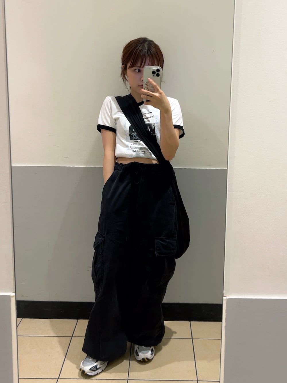 ブラック系のショルダーバッグ、ブラック系のカーゴパンツ、ホワイト系のTシャツ/カットソーを着用したレディースの夏コーディネートの2枚目の写真