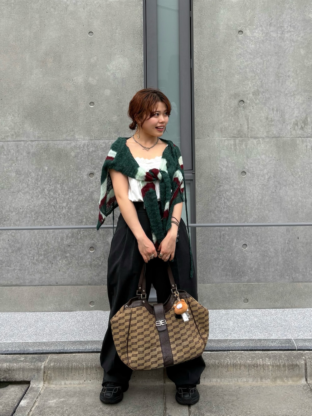 ブラック系のスニーカー、グレー系のスラックス、グリーン系のカーディガン/ボレロを着用したレディースの夏コーディネートの2枚目の写真