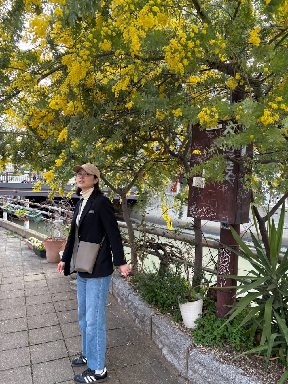 ブラック系のスニーカー、ブルー系のテーラードジャケット、ホワイト系のニット/セーターを着用したレディースの冬コーディネートの2枚目の写真