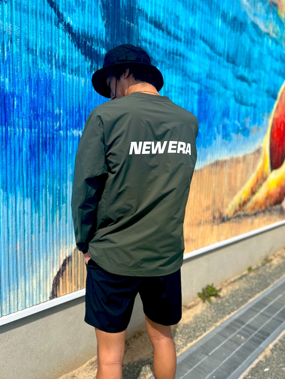 ブラック系のその他パンツ、ブラック系のサンダル、グリーン系のラッシュガードを着用したメンズの春コーディネートの2枚目の写真