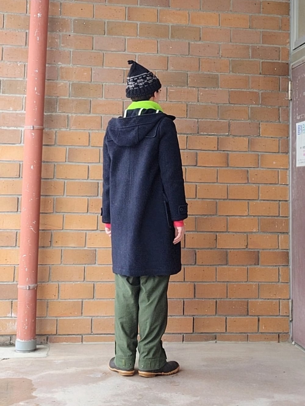 ブルー系のダッフルコート、ベージュ系のニット/セーター、ブルー系のTシャツ/カットソーを着用したレディースの冬コーディネートの2枚目の写真