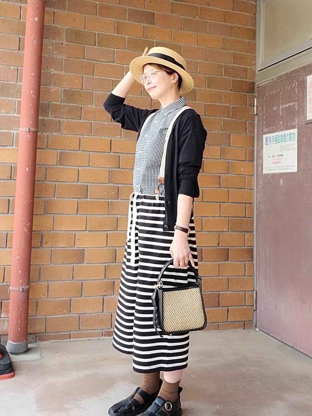 ブラック系のシャツ/ブラウス、ベージュ系のカーディガン/ボレロ、ブラック系のパンツを着用したレディースの春コーディネートの2枚目の写真