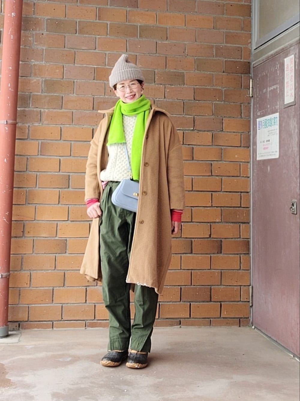 ブルー系のダッフルコート、ベージュ系のニット/セーター、ブルー系のTシャツ/カットソーを着用したレディースの冬コーディネートの3枚目の写真