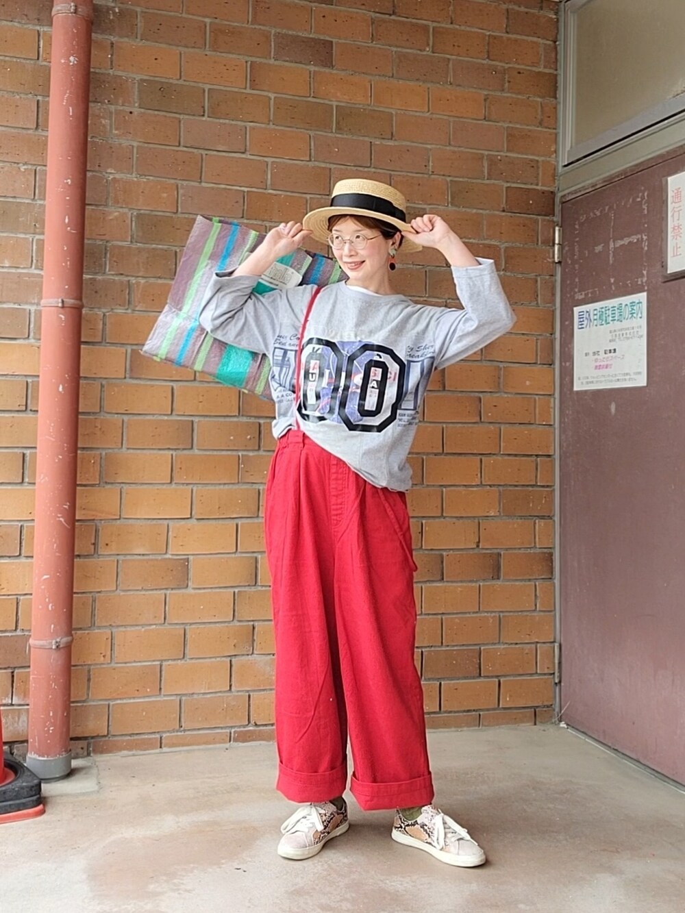 グレー系のTシャツ/カットソー、レッド系のその他パンツ、その他のトートバッグを着用したレディースの春コーディネートの3枚目の写真