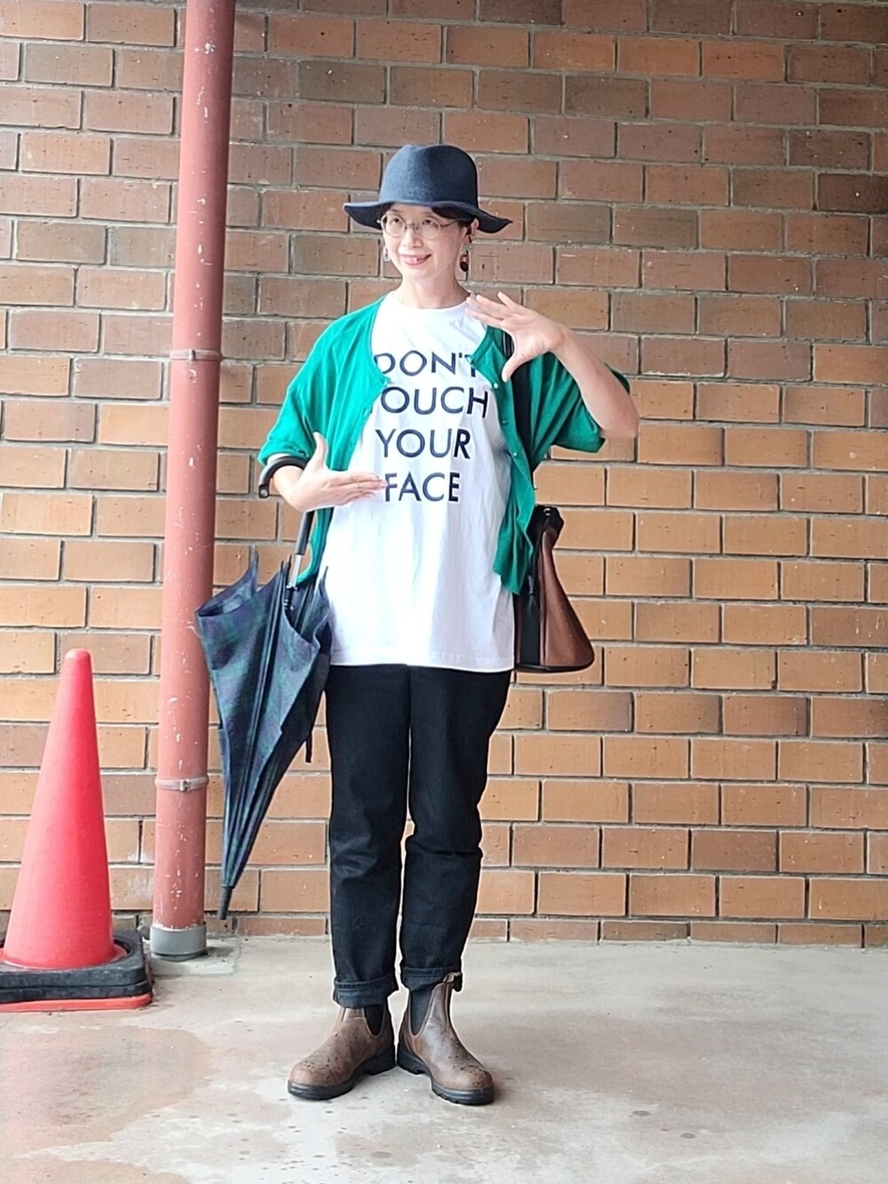 グリーン系のカーディガン/ボレロ、ホワイト系のTシャツ/カットソー、ブラウン系のブーツを着用したレディースの夏コーディネートの2枚目の写真