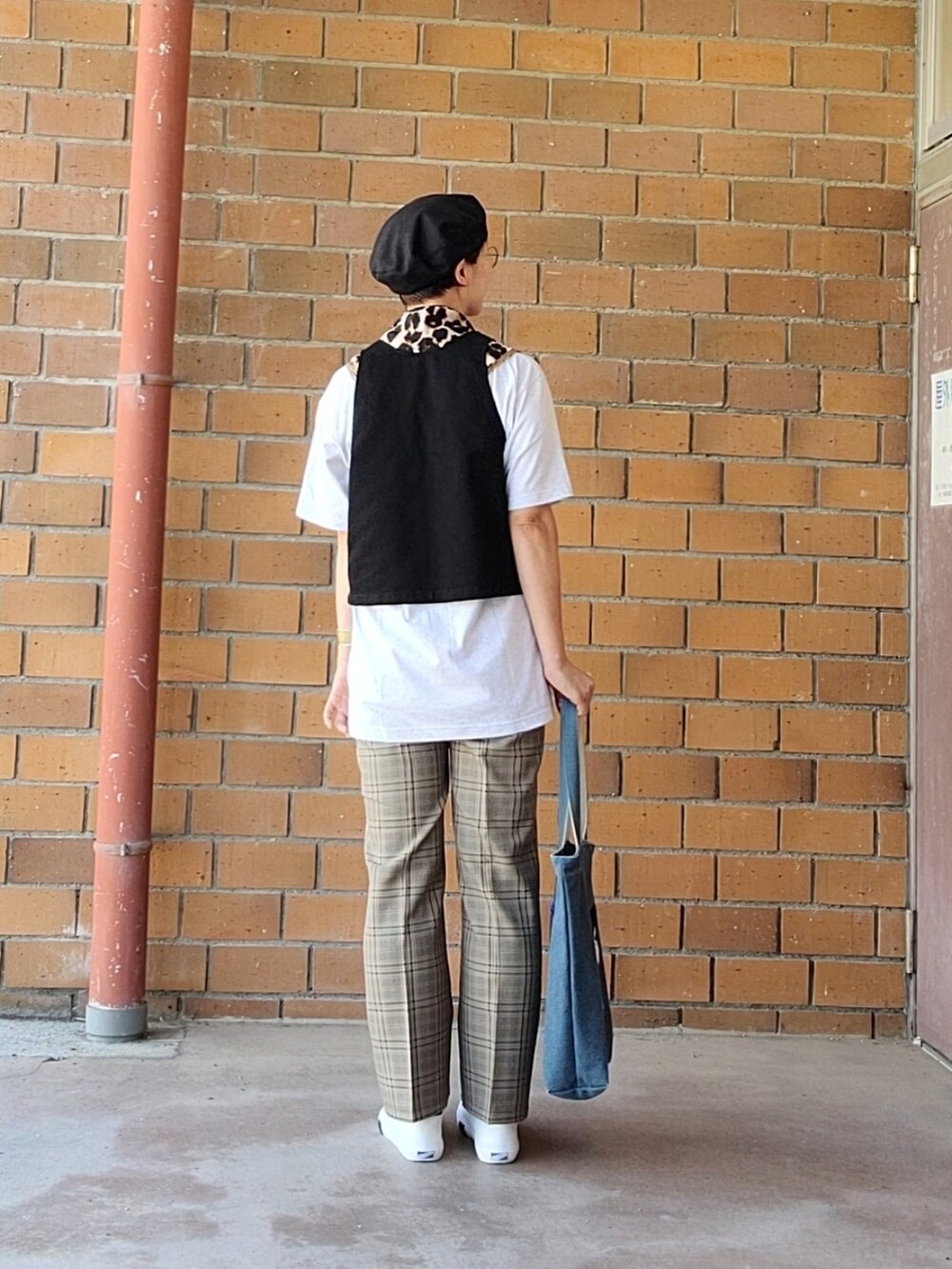 ブラック系のベスト、グレー系のTシャツ/カットソー、ベージュ系のスラックスを着用したレディースの秋コーディネートの5枚目の写真