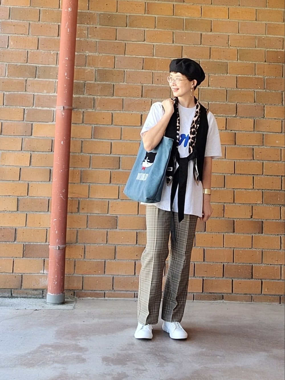 ブラック系のベスト、グレー系のTシャツ/カットソー、ベージュ系のスラックスを着用したレディースの秋コーディネートの2枚目の写真
