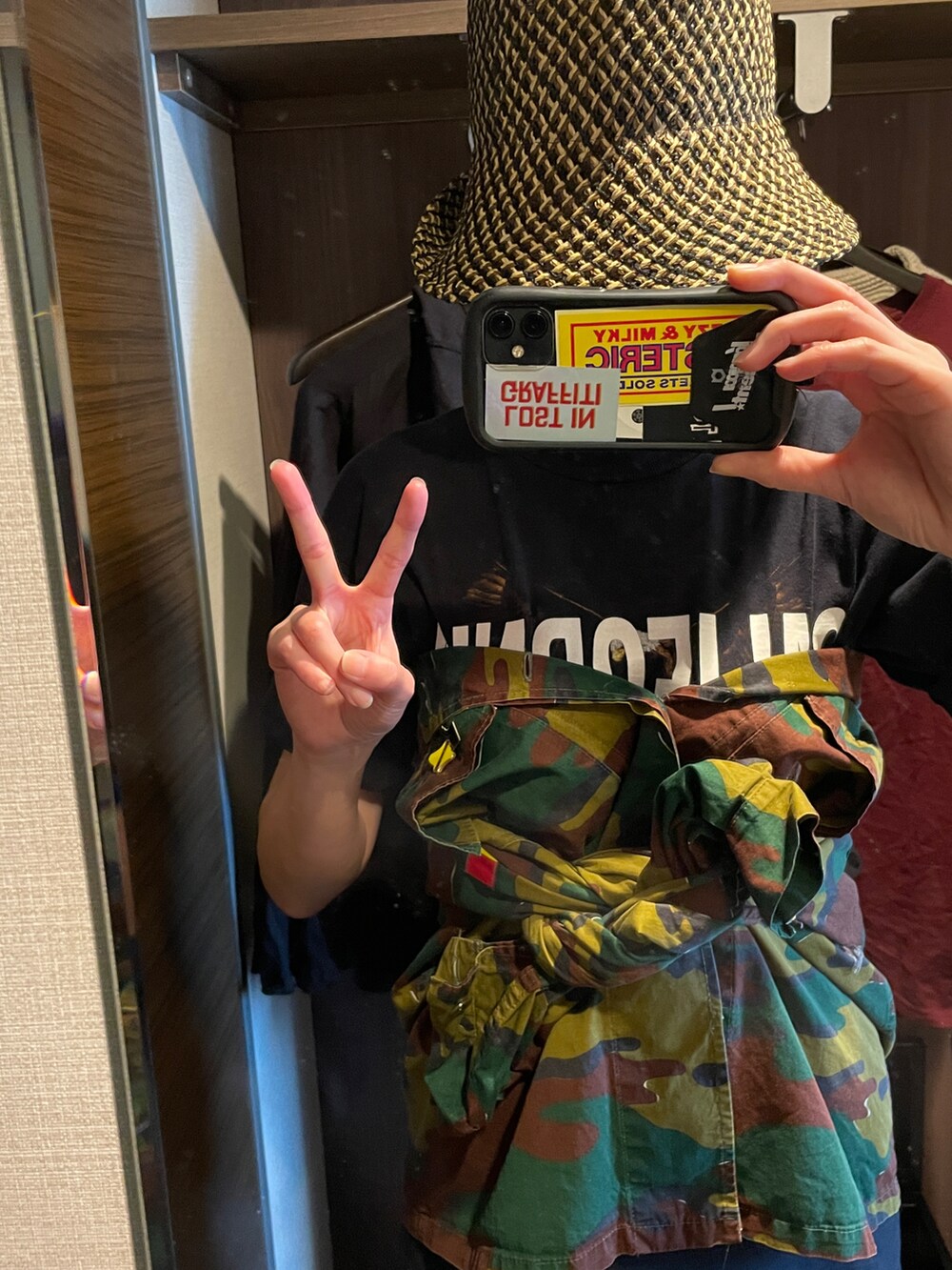 グリーン系のミリタリージャケット、ブラック系のTシャツ/カットソー、ブラック系のハットを着用したレディースの春コーディネートの2枚目の写真