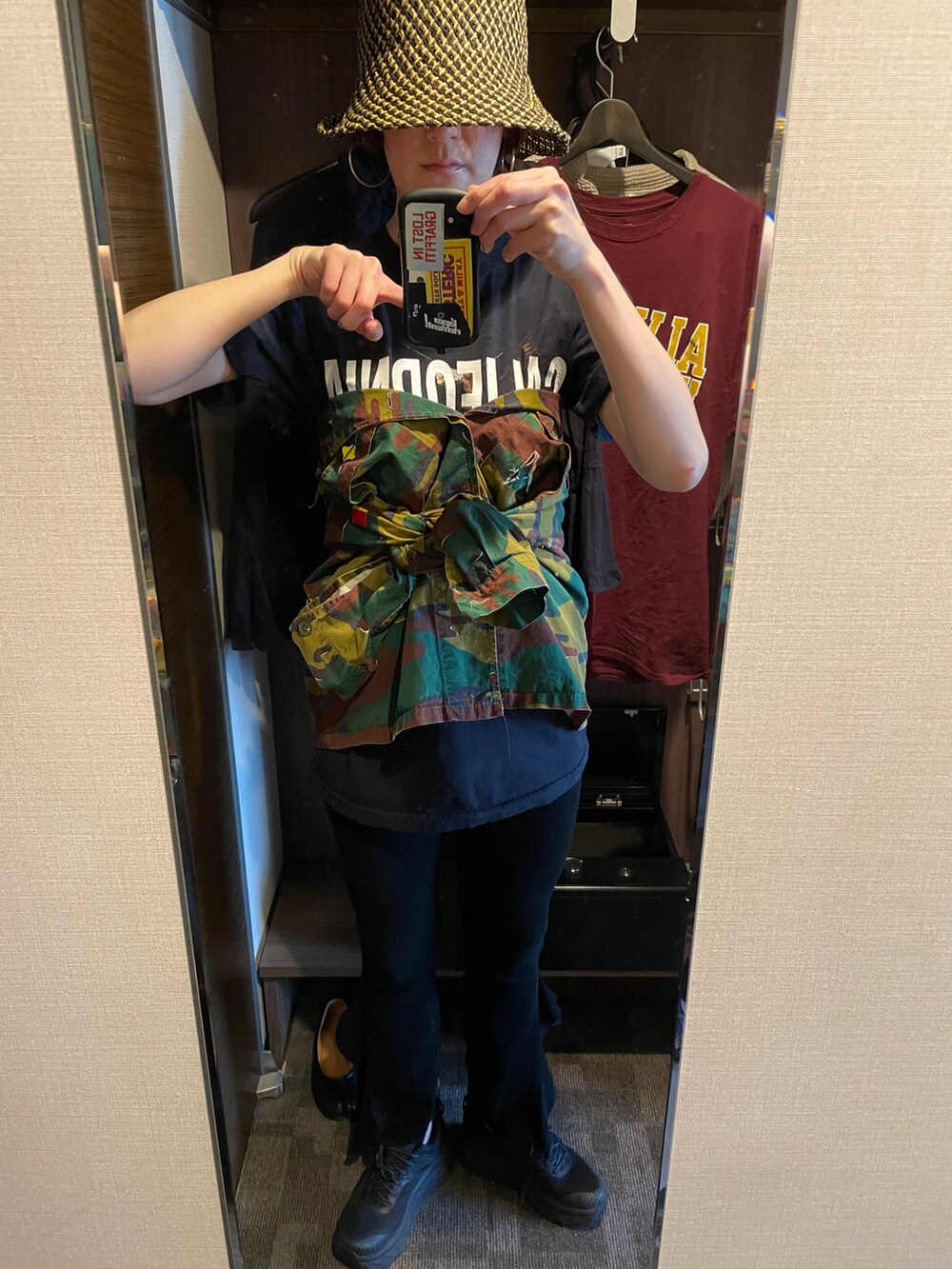 グリーン系のミリタリージャケット、ブラック系のTシャツ/カットソー、ブラック系のハットを着用したレディースの春コーディネートの3枚目の写真