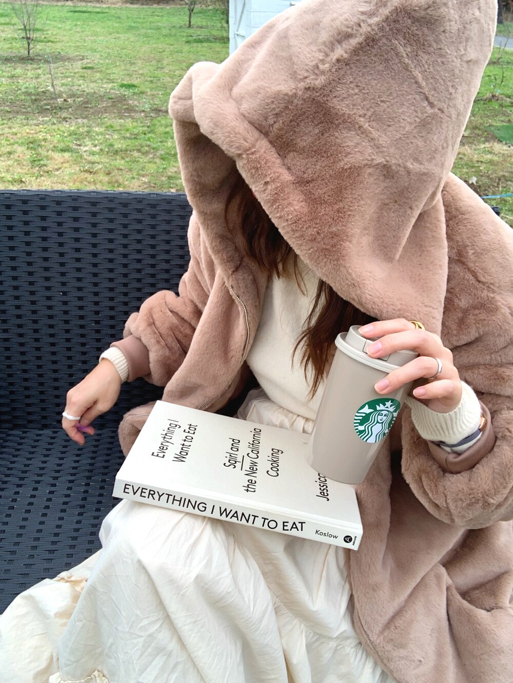 ブラウン系のブルゾン、ホワイト系のスカート、ブラウン系のトートバッグを着用したレディースの冬コーディネートの3枚目の写真