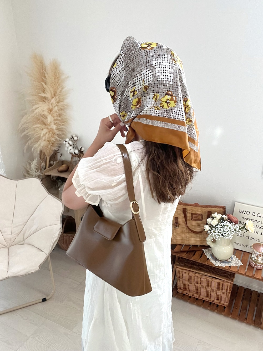 ブラウン系のハンドバッグ、ホワイト系のワンピースを着用したレディースの秋コーディネートの4枚目の写真