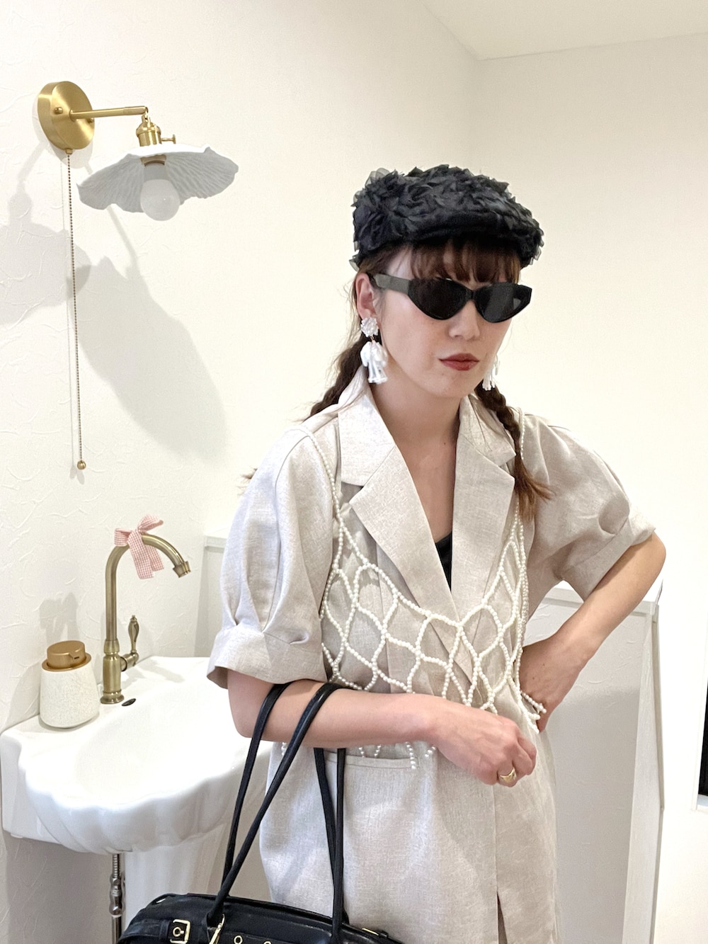 ブラック系のボストンバッグ、ブラック系のキャミソール、ブラック系のハンチング/ベレー帽を着用したレディースの春コーディネートの4枚目の写真