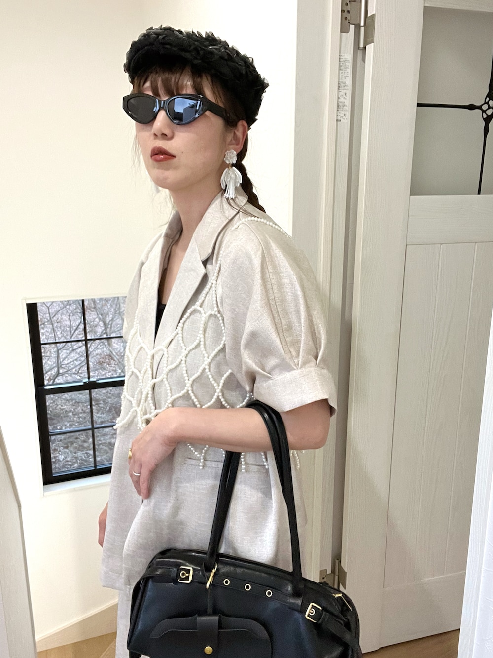 ブラック系のボストンバッグ、ブラック系のキャミソール、ブラック系のハンチング/ベレー帽を着用したレディースの春コーディネートの5枚目の写真