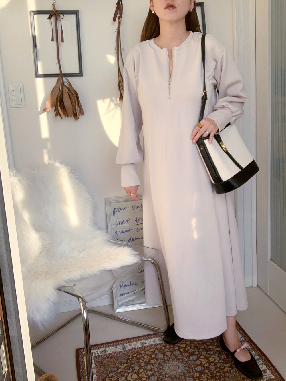 ブラック系のパンプス、ブラック系のトートバッグ、ホワイト系のワンピースを着用したレディースの秋コーディネートの2枚目の写真