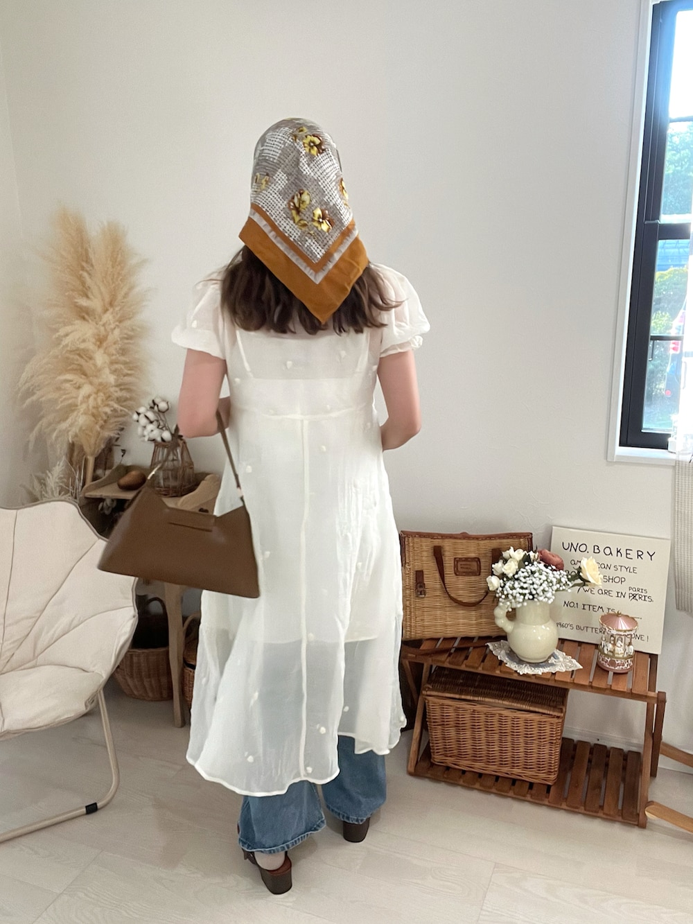 ブラウン系のハンドバッグ、ホワイト系のワンピースを着用したレディースの秋コーディネートの2枚目の写真