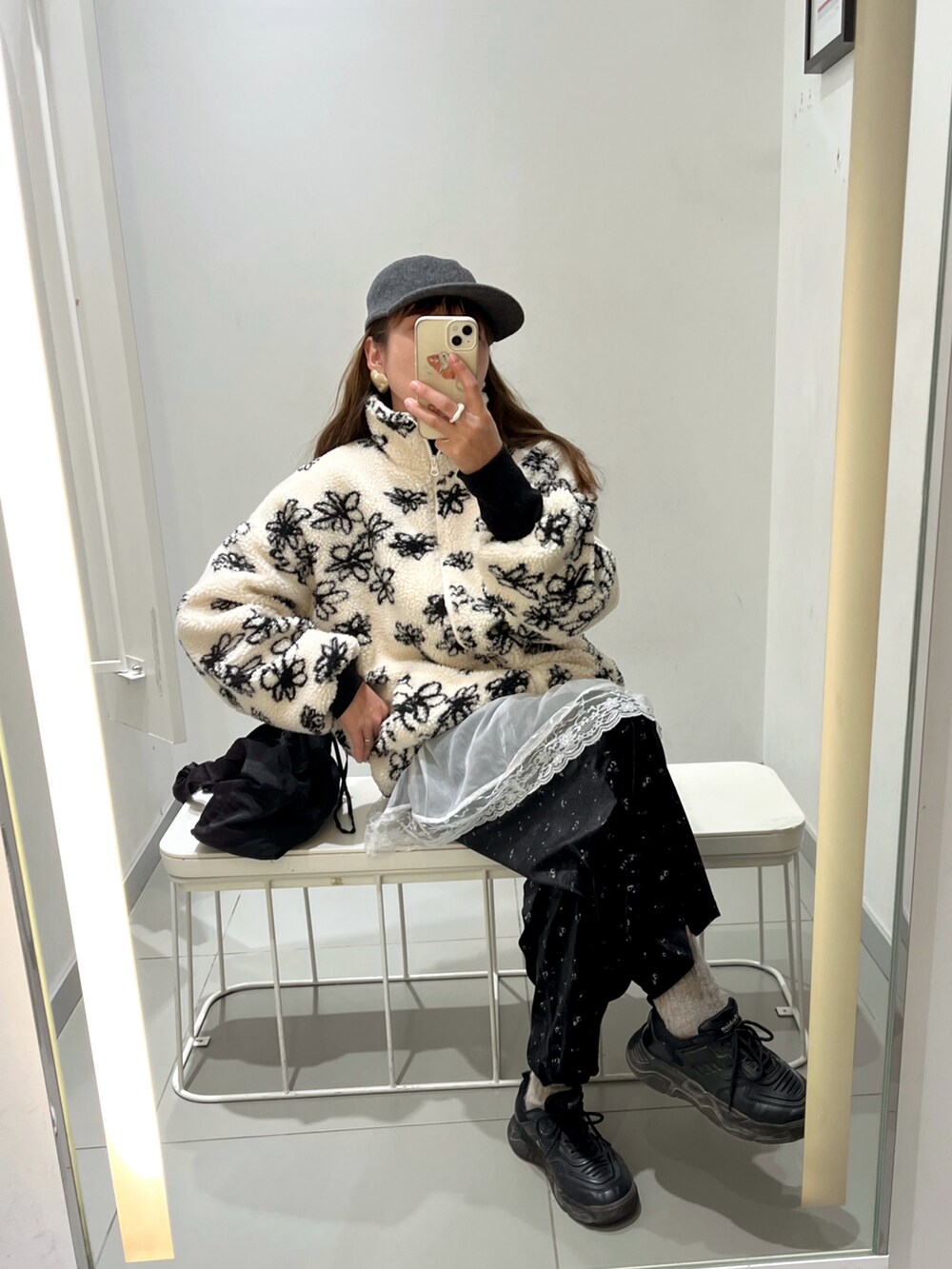 ブラック系のスニーカー、ブラック系のハンドバッグを着用したレディースの春コーディネートの2枚目の写真