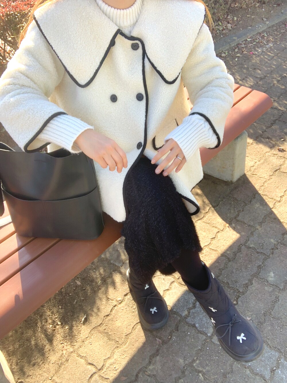 ブラック系のトートバッグ、ブラック系のスカート、ベージュ系のキャスケットを着用したレディースの冬コーディネートの3枚目の写真