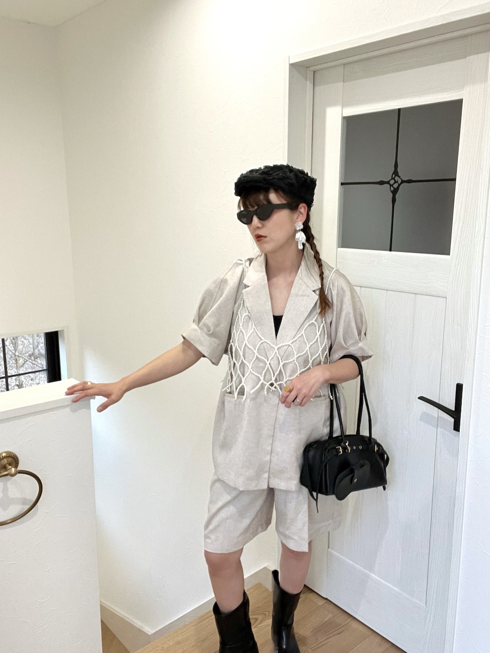 ブラック系のボストンバッグ、ブラック系のキャミソール、ブラック系のハンチング/ベレー帽を着用したレディースの春コーディネートの2枚目の写真