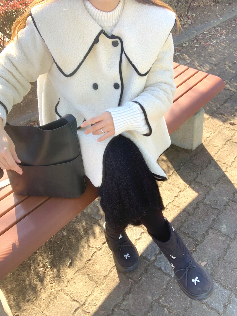 ブラック系のトートバッグ、ブラック系のスカート、ベージュ系のキャスケットを着用したレディースの冬コーディネートの4枚目の写真