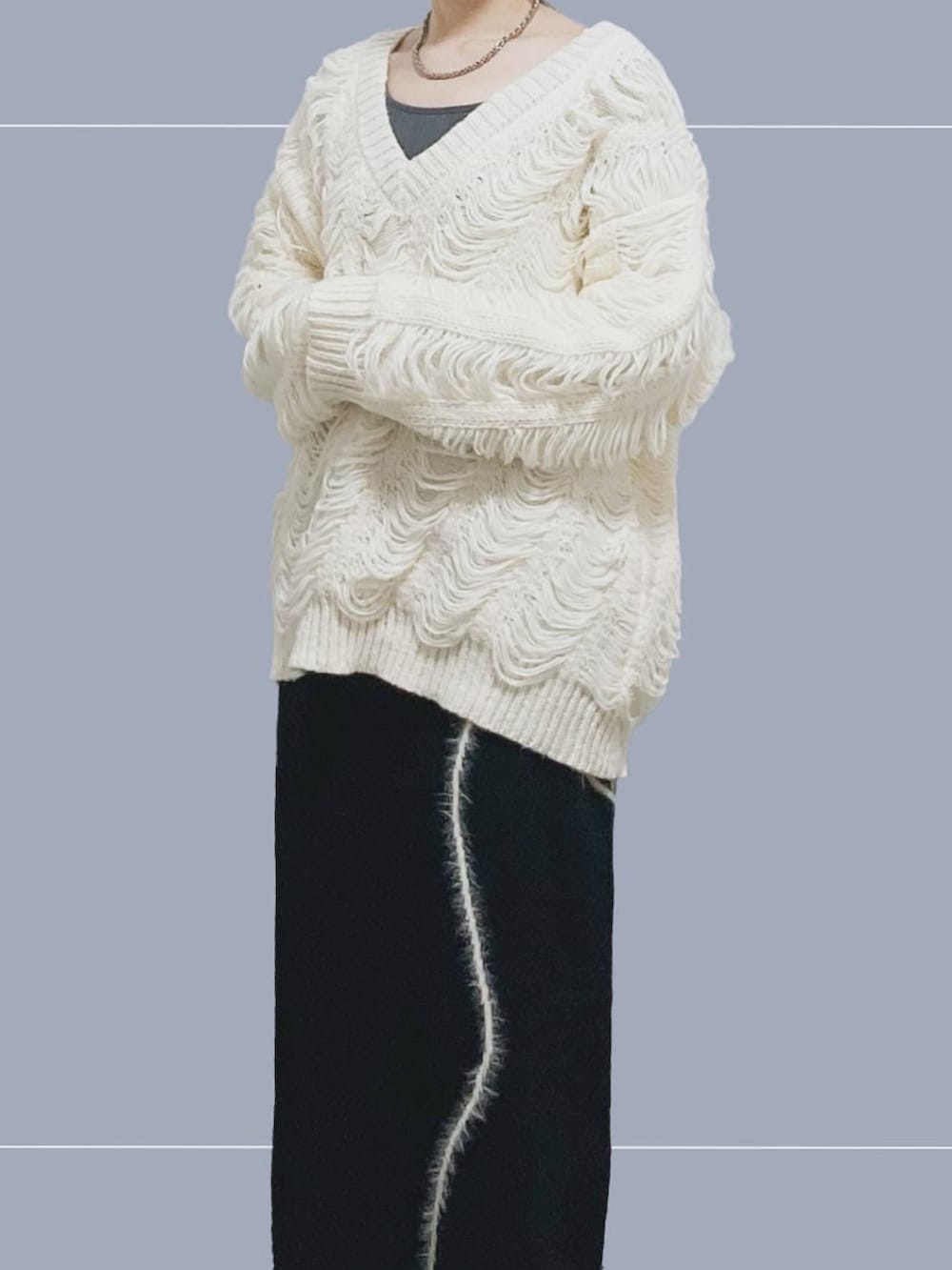 グレー系のTシャツ/カットソー、ホワイト系のニット/セーター、ブラック系のスカートを着用したレディースの春コーディネートの2枚目の写真