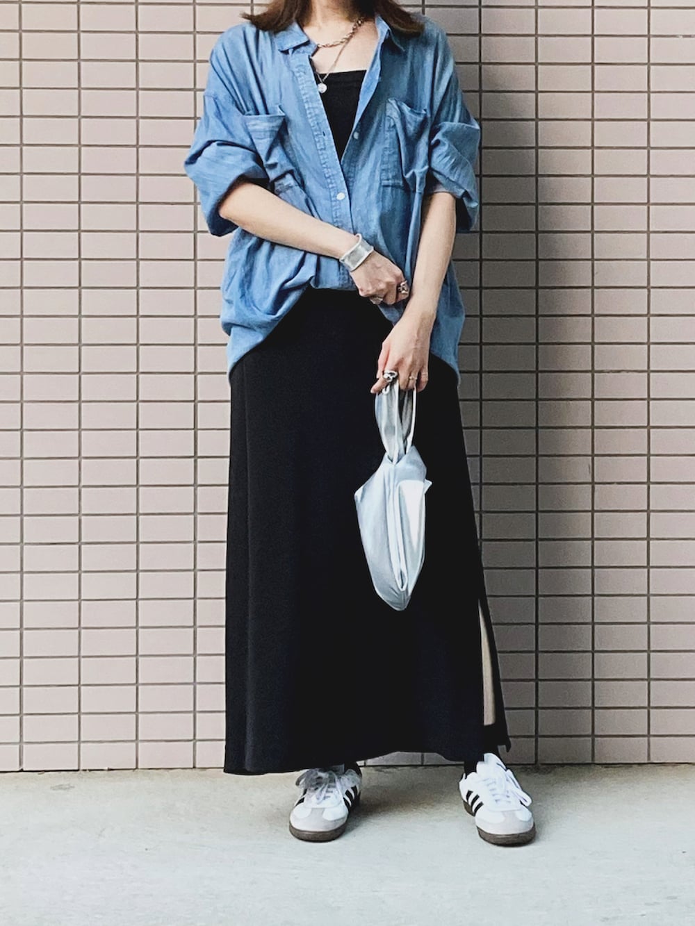 ブルー系のシャツ/ブラウス、シルバー系のハンドバッグ、ブラック系のワンピースを着用したレディースの秋コーディネートの2枚目の写真
