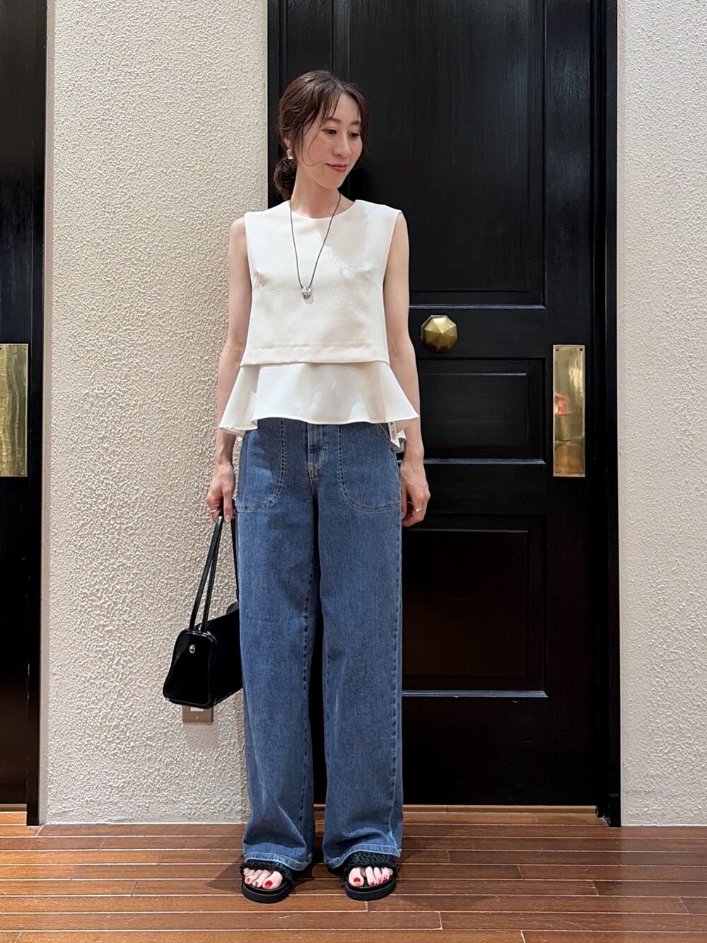 ブルー系のデニムパンツ、ベージュ系のシャツ/ブラウス、ブラック系のサンダルを着用したレディースの夏コーディネートの2枚目の写真