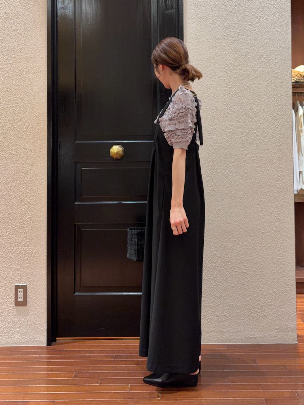 ブラック系のサロペット/オーバーオール、グレー系のニット/セーターを着用したレディースの春コーディネートの2枚目の写真