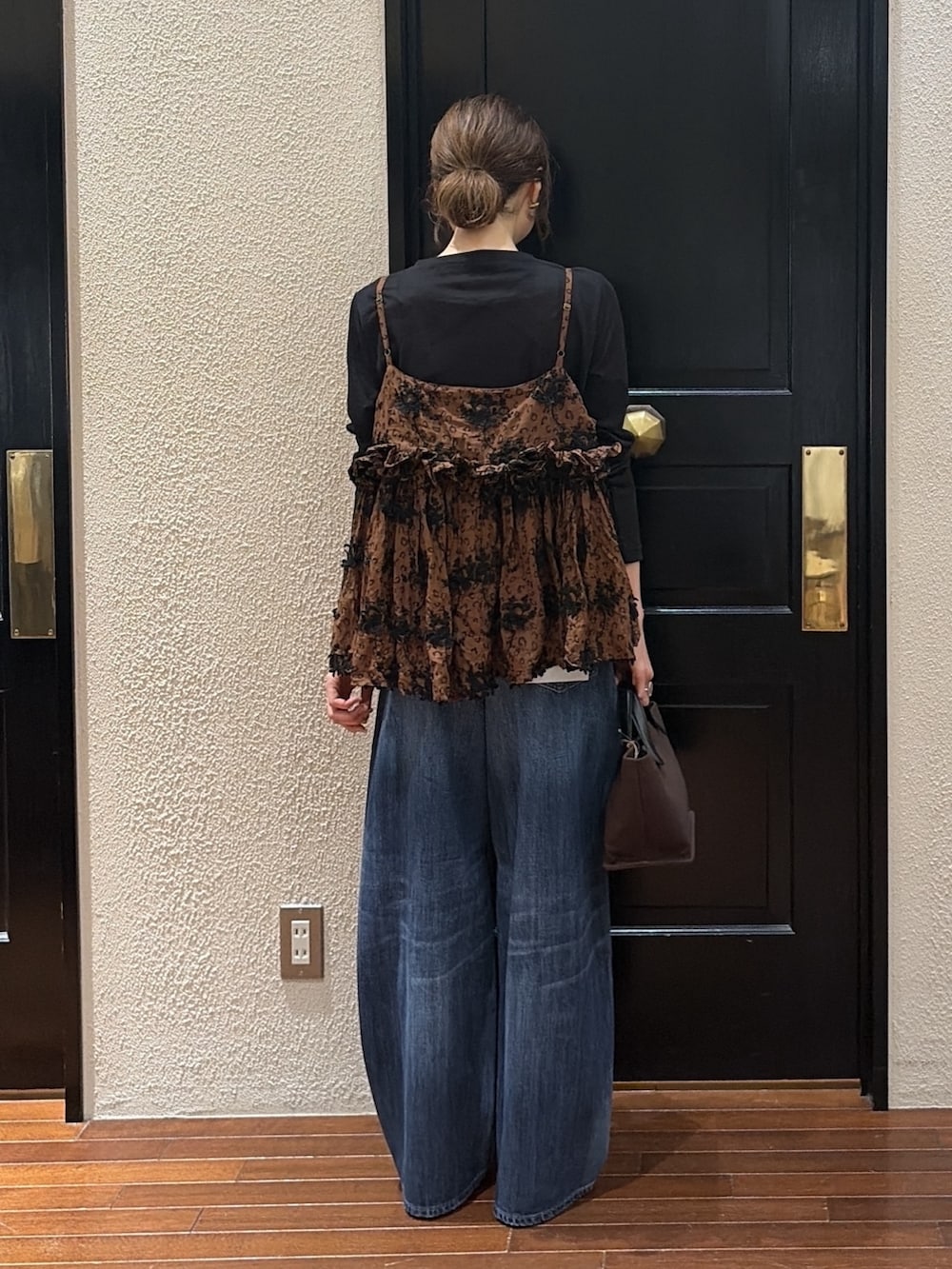ブラウン系のキャミソール、ブルー系のデニムパンツ、ブラック系のTシャツ/カットソーを着用したレディースの秋コーディネートの3枚目の写真