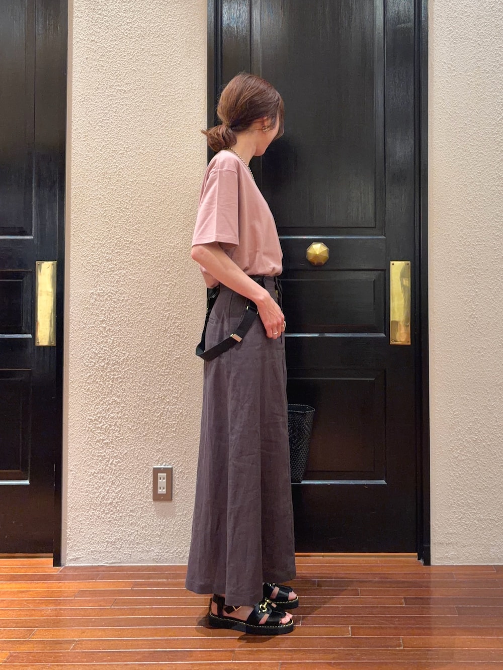 グレー系のスカート、ピンク系のTシャツ/カットソー、ブラック系のかごバッグを着用したレディースの春コーディネートの2枚目の写真