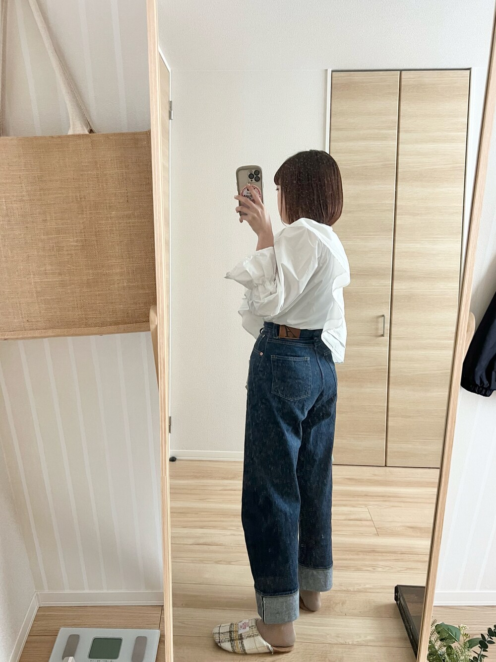 ブルー系のデニムパンツ、イエロー系のハンドバッグ、グリーン系のテーラードジャケットを着用したレディースの春コーディネートの2枚目の写真