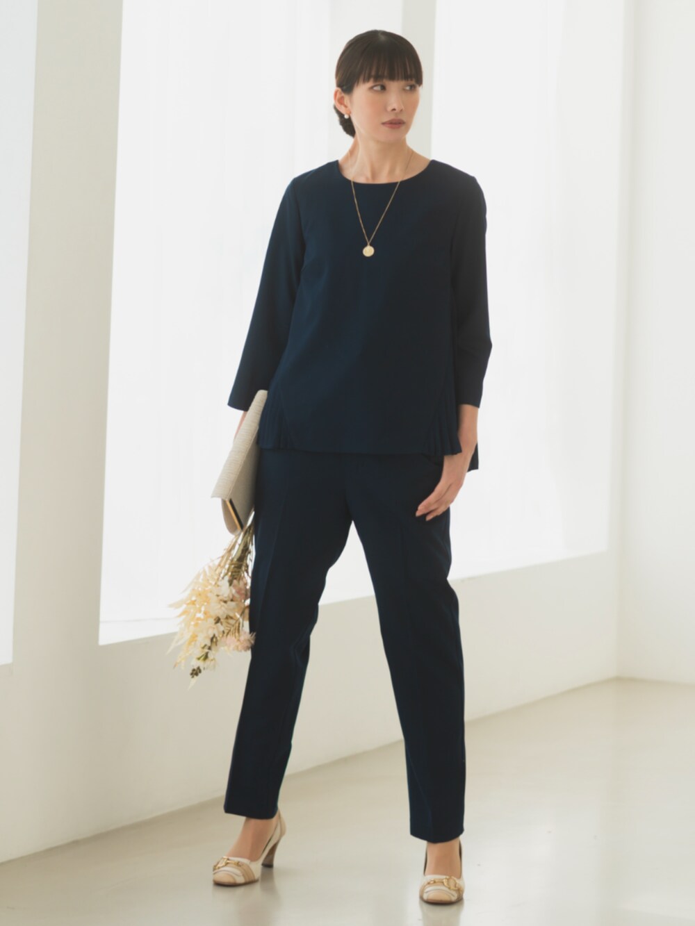 ブルー系のシャツ/ブラウス、ブルー系のスーツパンツ、ゴールド系のハンドバッグを着用したレディースの冬コーディネートの2枚目の写真