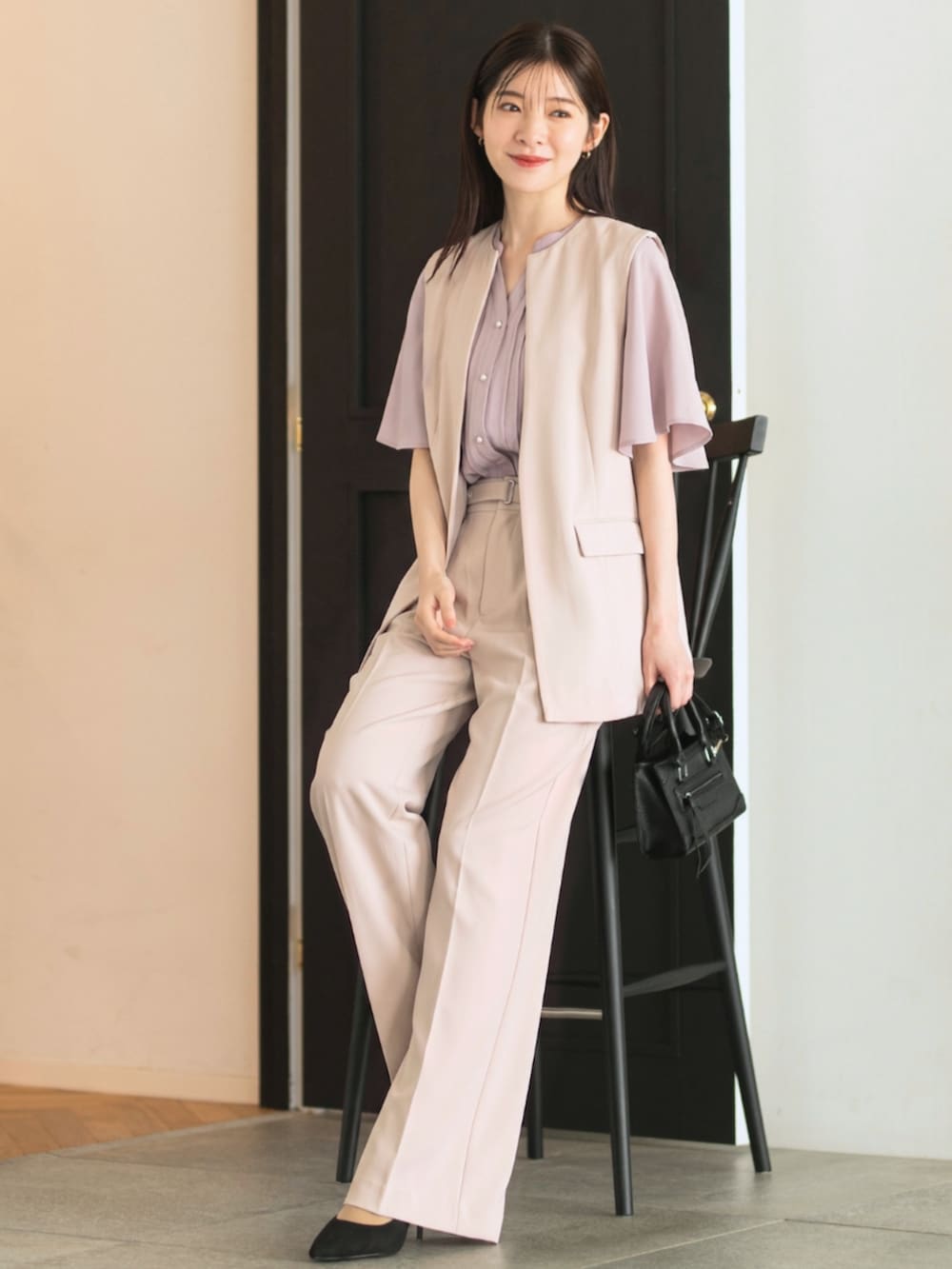 ピンク系のシャツ/ブラウス、ベージュ系のスーツベスト、ベージュ系のスーツパンツを着用したレディースの夏コーディネートの2枚目の写真