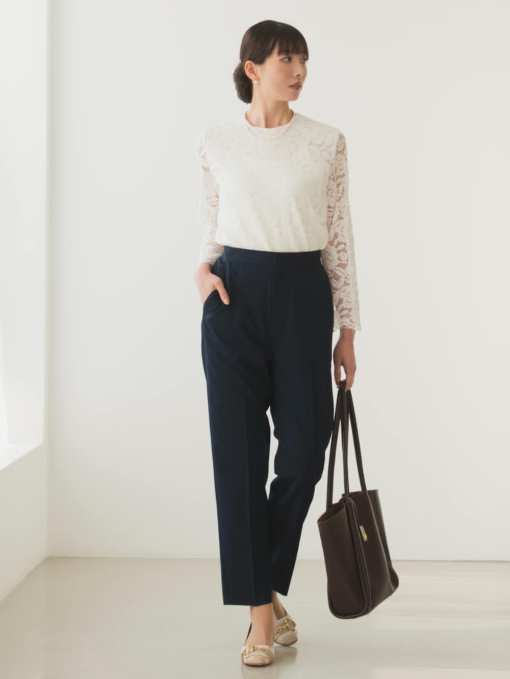 ブルー系のシャツ/ブラウス、ブルー系のスーツパンツ、ゴールド系のハンドバッグを着用したレディースの冬コーディネートの3枚目の写真