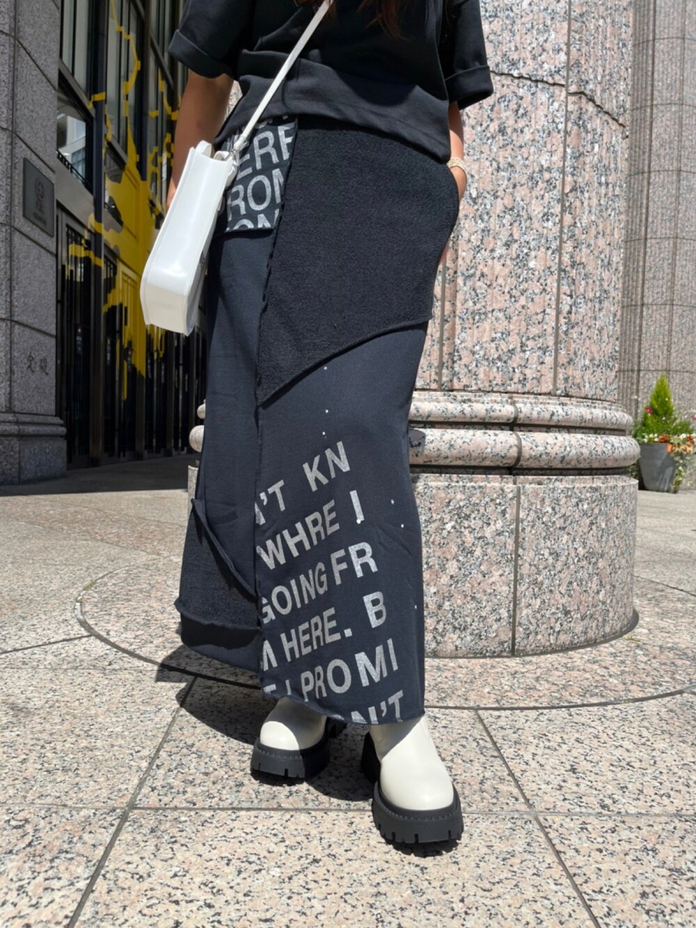 ホワイト系のシューズ、ブラック系のスカート、ブラック系のTシャツ/カットソーを着用したレディースの夏コーディネートの3枚目の写真