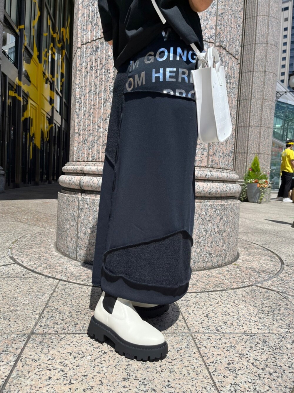 ホワイト系のシューズ、ブラック系のスカート、ブラック系のTシャツ/カットソーを着用したレディースの夏コーディネートの5枚目の写真