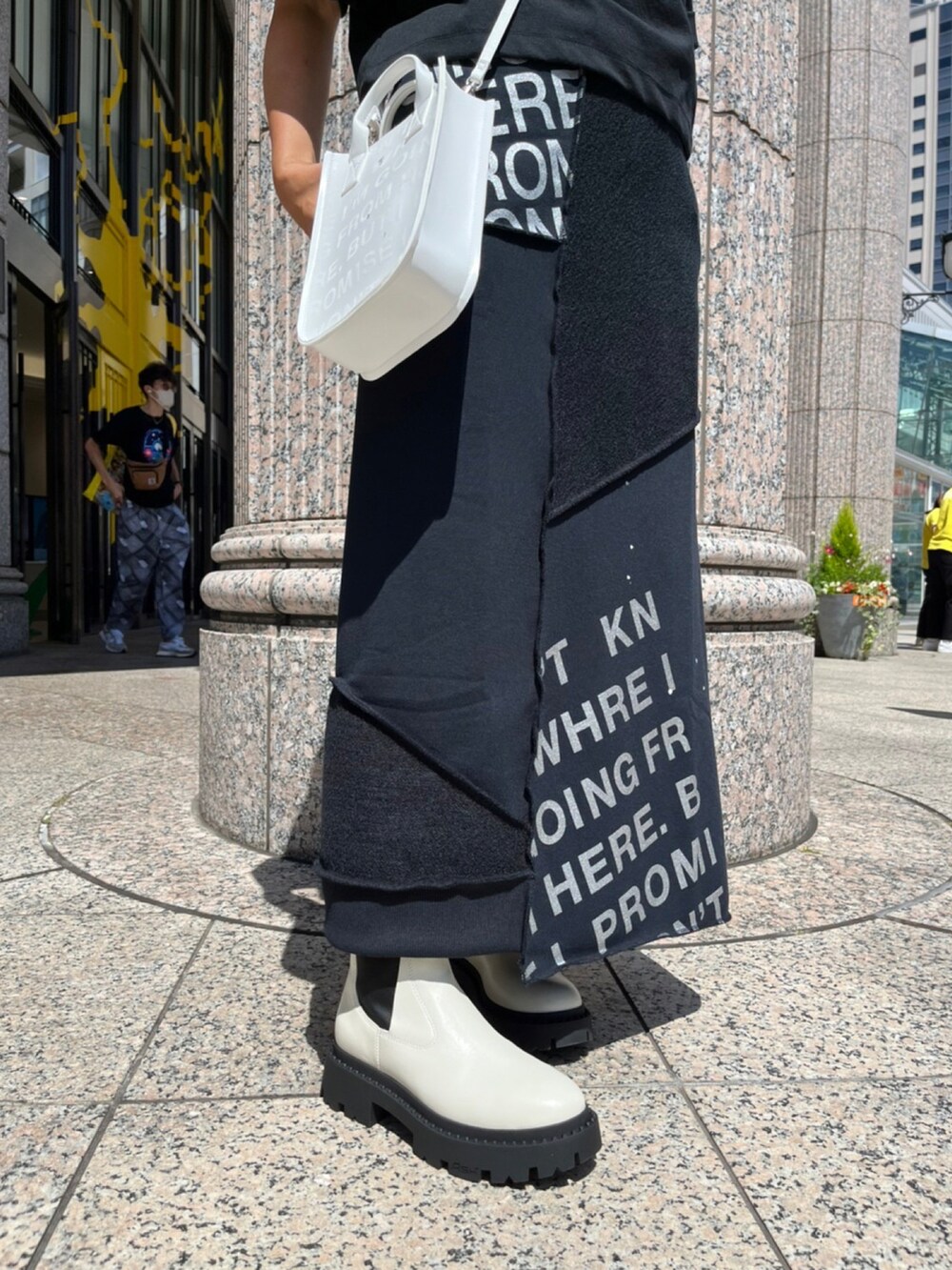 ホワイト系のシューズ、ブラック系のスカート、ブラック系のTシャツ/カットソーを着用したレディースの夏コーディネートの4枚目の写真