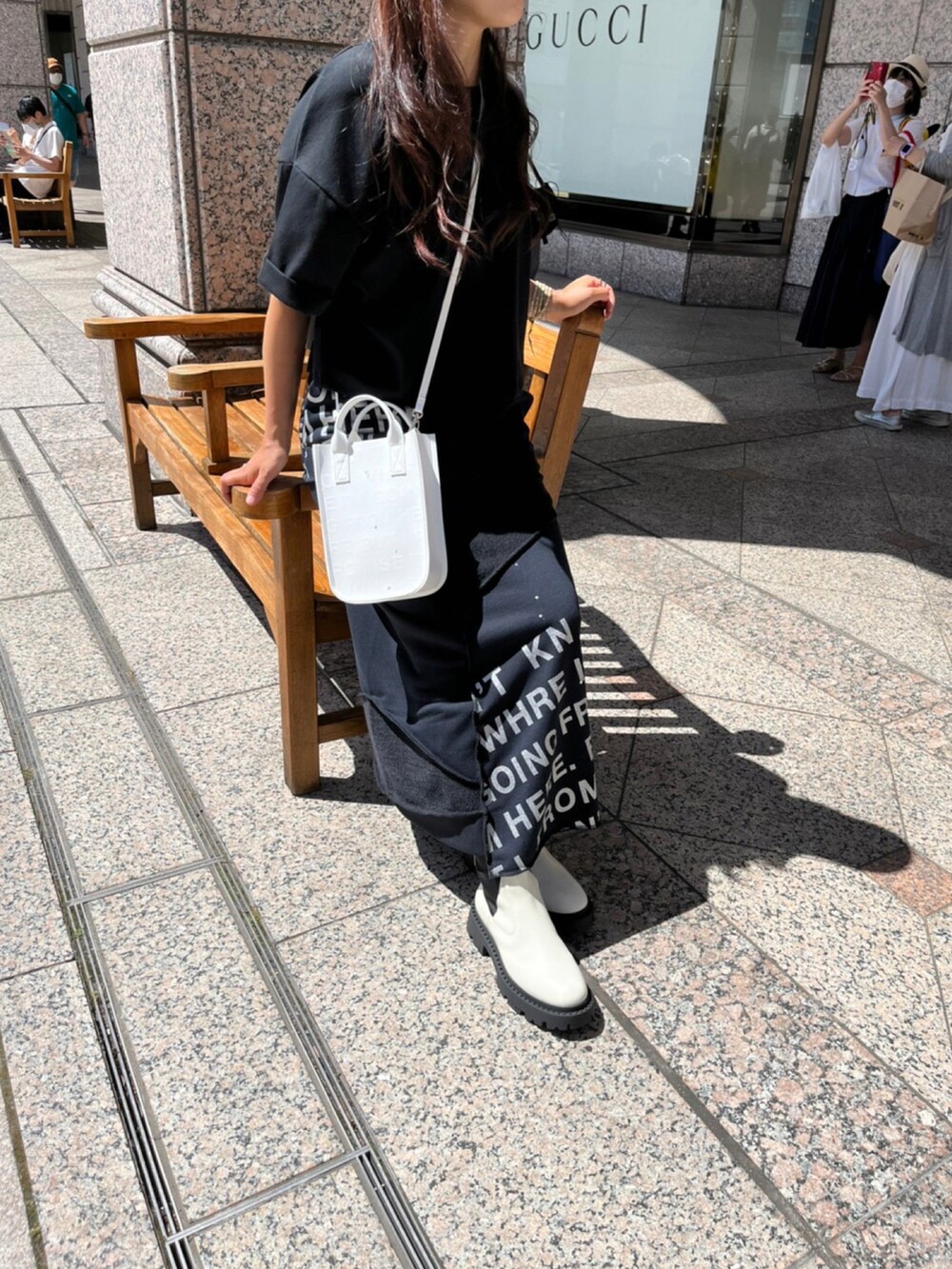 ホワイト系のシューズ、ブラック系のスカート、ブラック系のTシャツ/カットソーを着用したレディースの夏コーディネートの2枚目の写真