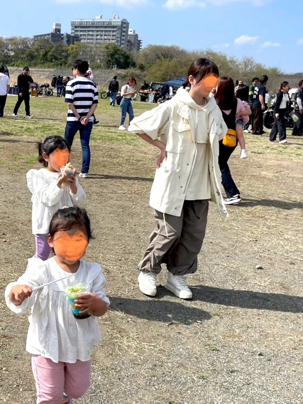 ホワイト系のベスト、ホワイト系のパーカー、グリーン系のスカートを着用したレディースの春コーディネートの2枚目の写真