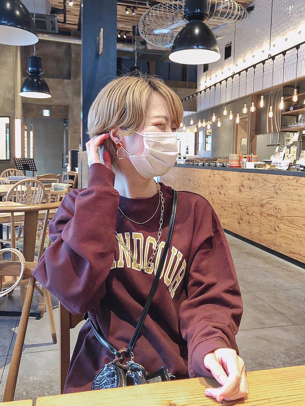 ブラウン系のスウェット、ホワイト系のスカート、ブラック系のローファーを着用したレディースの秋コーディネートの2枚目の写真