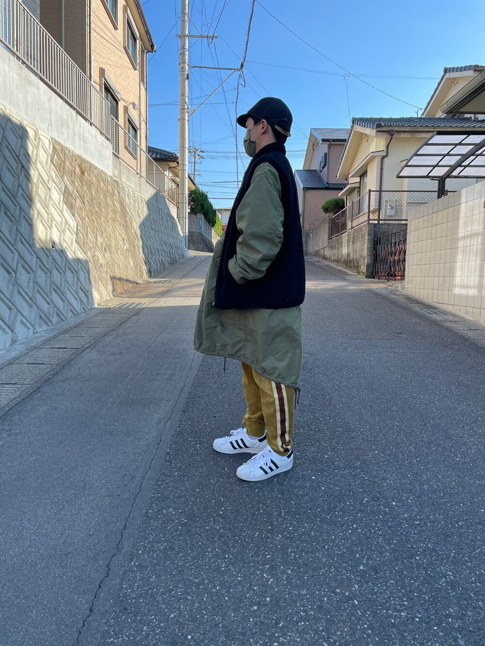 グリーン系のモッズコート、ホワイト系のTシャツ/カットソー、ブラウン系のその他パンツを着用したキッズの冬コーディネートの2枚目の写真