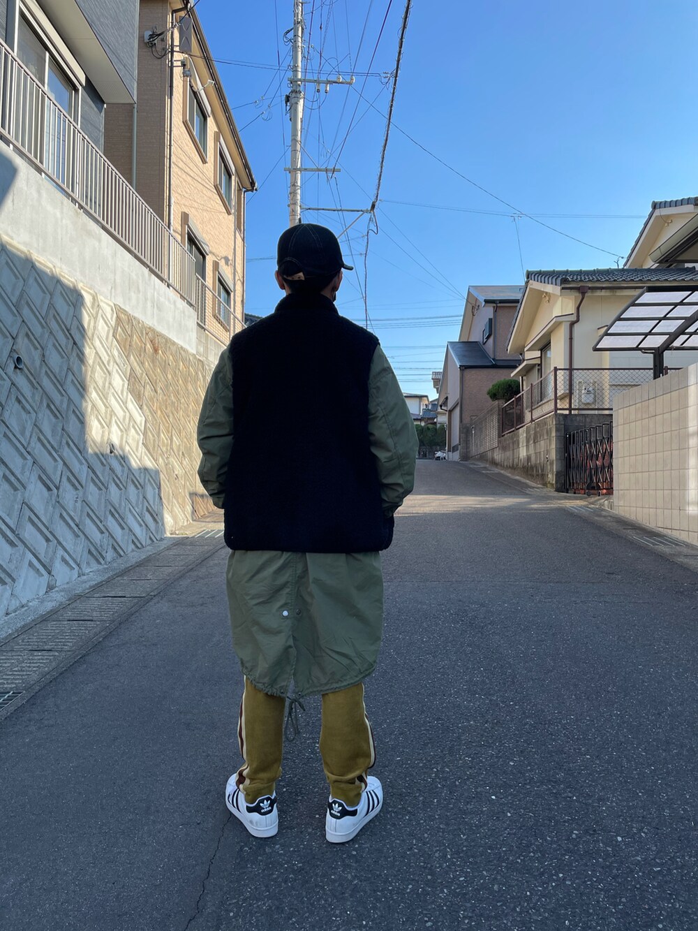 グリーン系のモッズコート、ホワイト系のTシャツ/カットソー、ブラウン系のその他パンツを着用したキッズの冬コーディネートの3枚目の写真