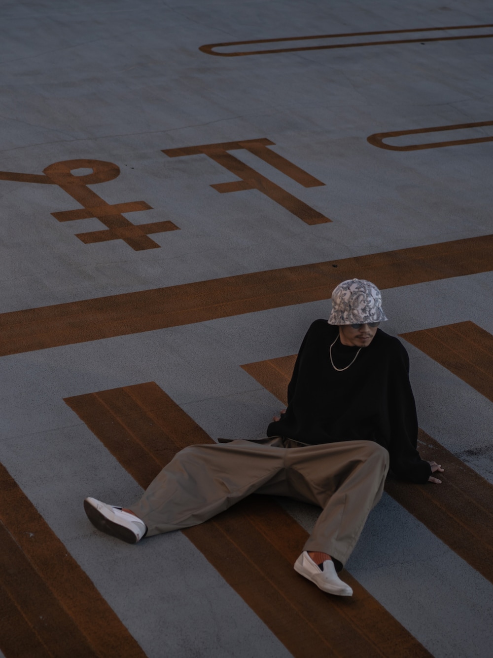 ホワイト系のスニーカー、ホワイト系のハットを着用したメンズの秋コーディネートの3枚目の写真