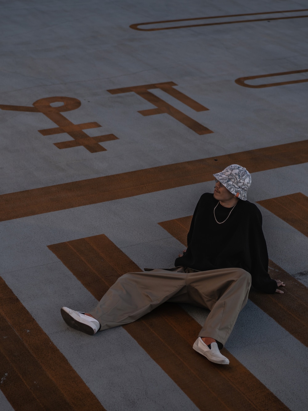 ホワイト系のスニーカー、ホワイト系のハットを着用したメンズの秋コーディネートの2枚目の写真