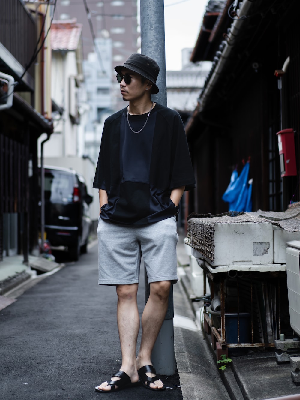 ブラック系のTシャツ/カットソー、グレー系のパンツ、ブラック系のサンダルを着用したメンズの夏コーディネートの2枚目の写真