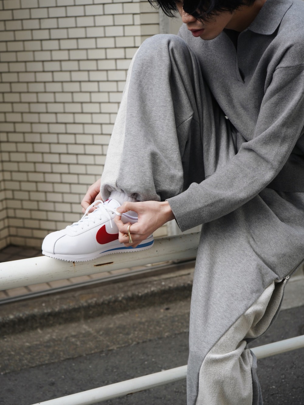 ホワイト系のスニーカーを着用したメンズの春コーディネートの2枚目の写真