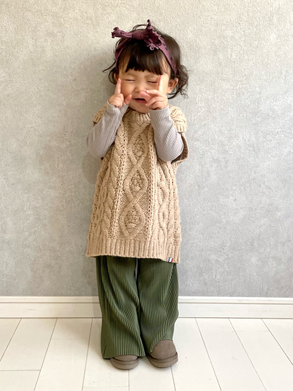 ベージュ系のベスト、グリーン系のパンツ、ブラウン系のTシャツ/カットソーを着用したキッズの秋コーディネートの2枚目の写真