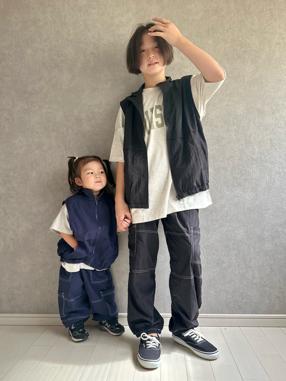 ベージュ系のTシャツ/カットソー、ブラック系のベスト、ブラック系のスニーカーを着用したキッズの夏コーディネートの3枚目の写真