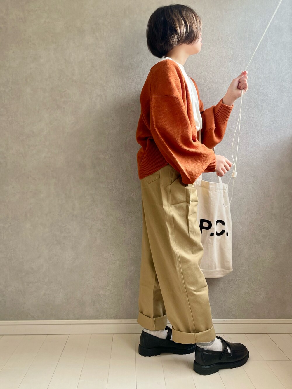 ホワイト系のTシャツ/カットソー、オレンジ系のカーディガン/ボレロ、ベージュ系のデニムパンツを着用したキッズの秋コーディネートの2枚目の写真